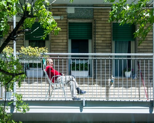 Person relaxing on a balcony with plants, enjoying the afternoon without devices