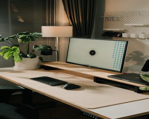Ergonomic home office setup with monitor at eye level and soft natural lighting